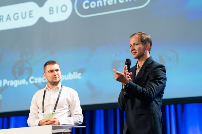 Daniel Kvak and Bristol Myers giving a lecture on stage...