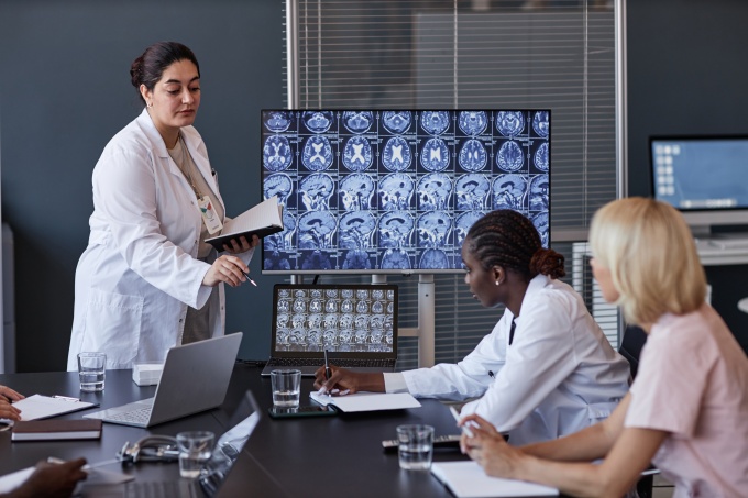 Radiologist presenting brain MRI results to colleagues in a meeting....