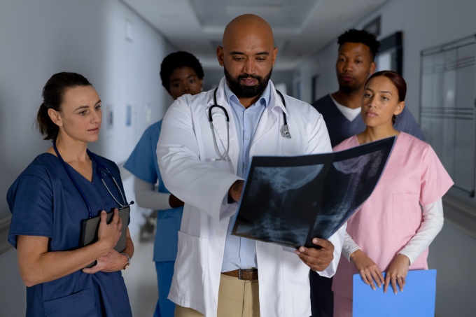 A doctor explains an X-ray image to a group of medical staff in a hospital...