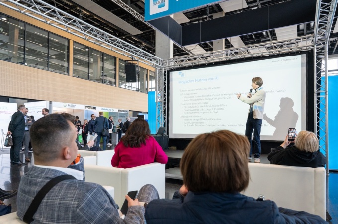 Person talking in front of a big screen showing a presentation on AI in...