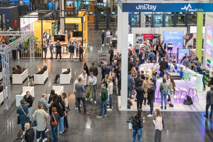 Trade fair hall with visitors walking through it.