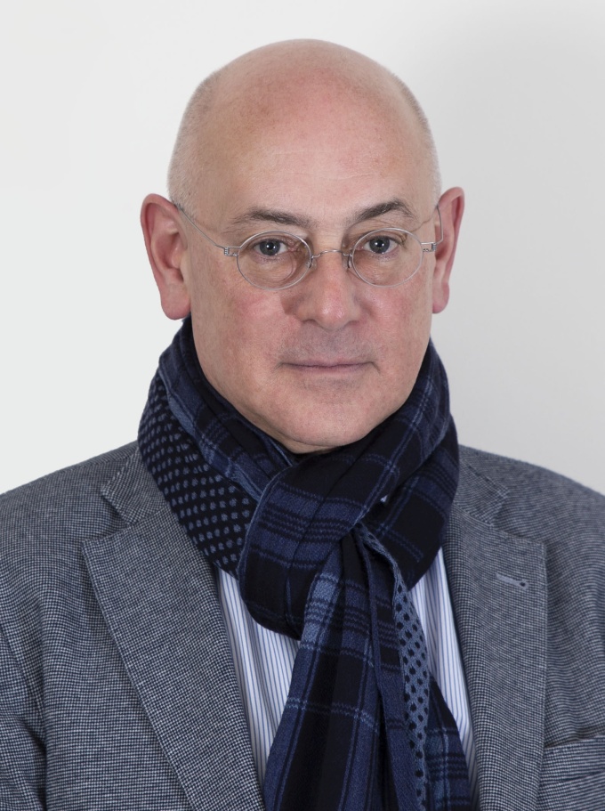 Portrait of a man looking directly at the camera, wearing a suit and a scarf...