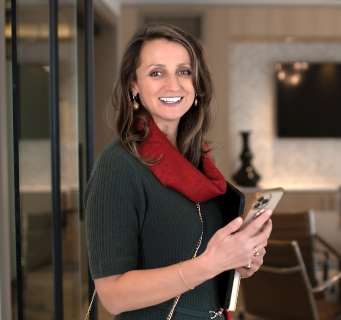 Smiling woman holding a cellphone in one hand