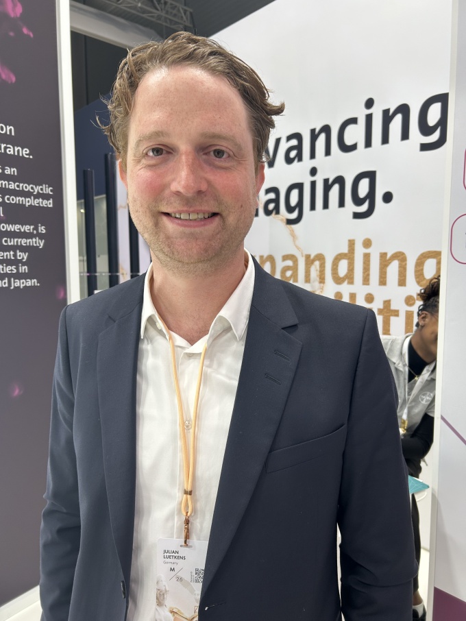 Man in a suit smiling at the camera at a congress