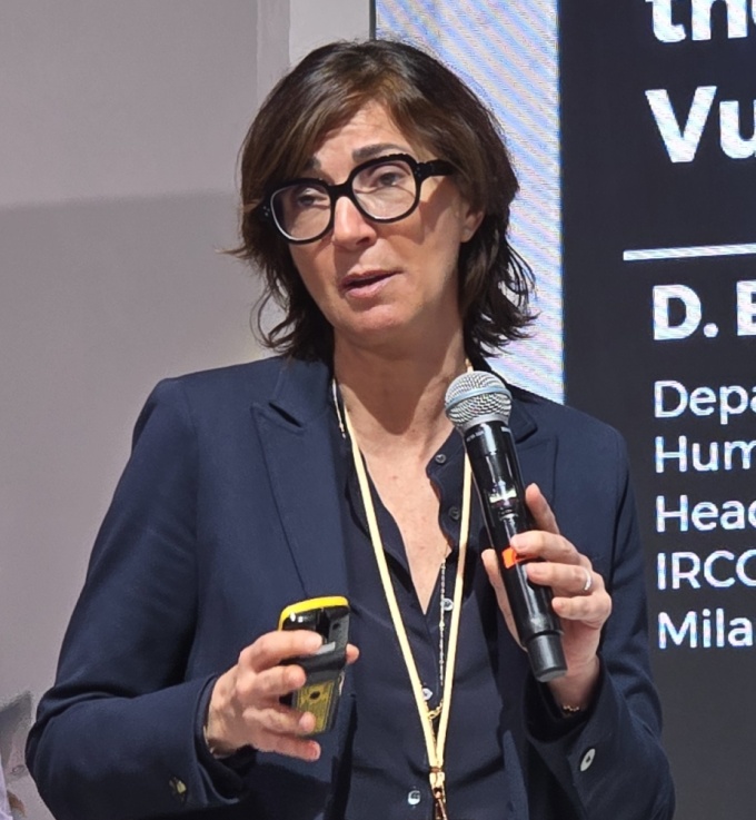 Woman holding a microphone while talking: Daniela Bernardi...